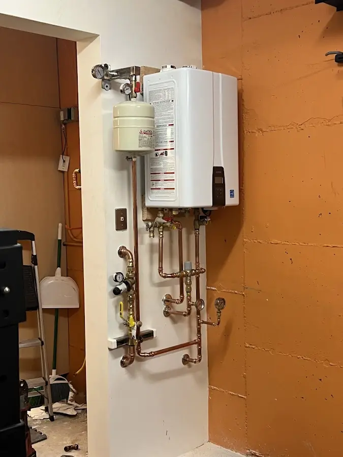 Plumbing technician inspecting water heater connections in Woodcrest